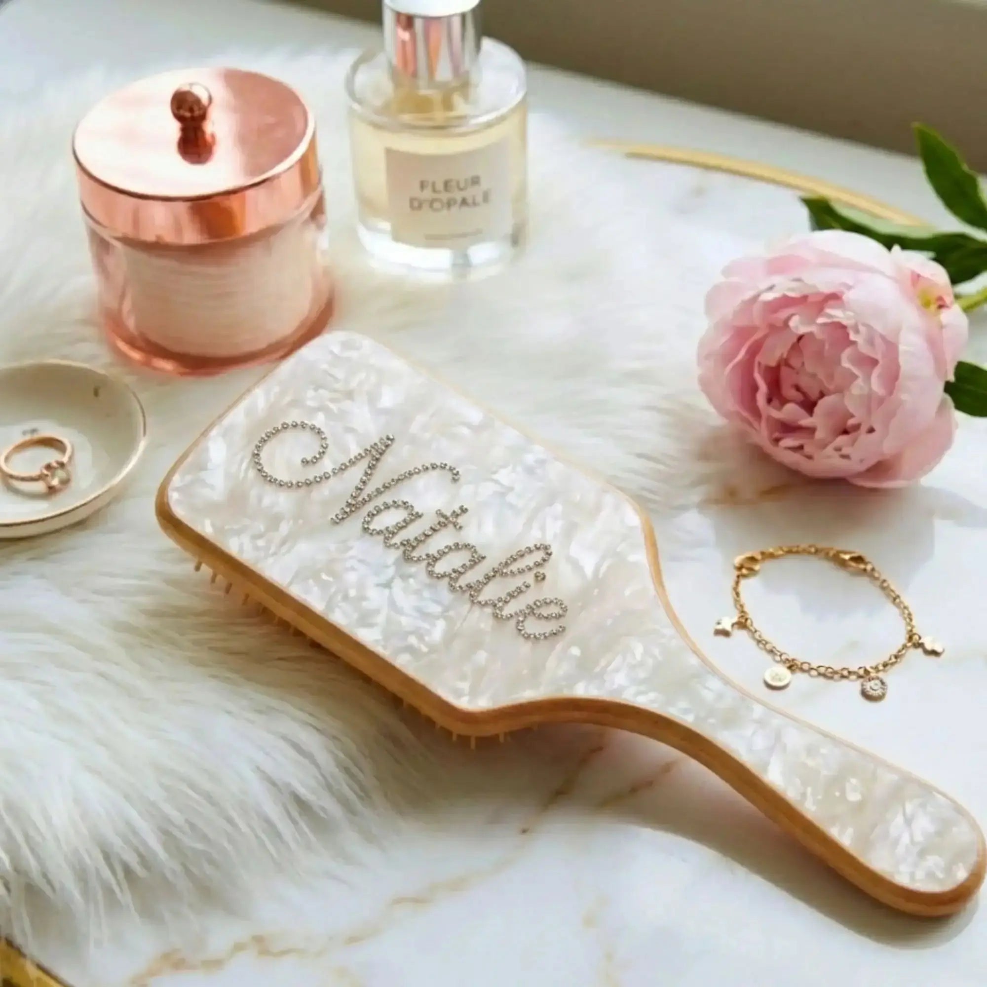 Pearl-look air-cushion hair brush with rhinestone script on clear, gold-edged pad