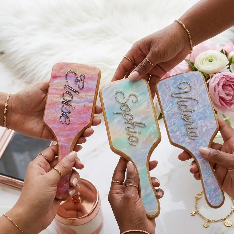 Three pastel air-cushion hair brushes with different rhinestone butterfly/scroll designs