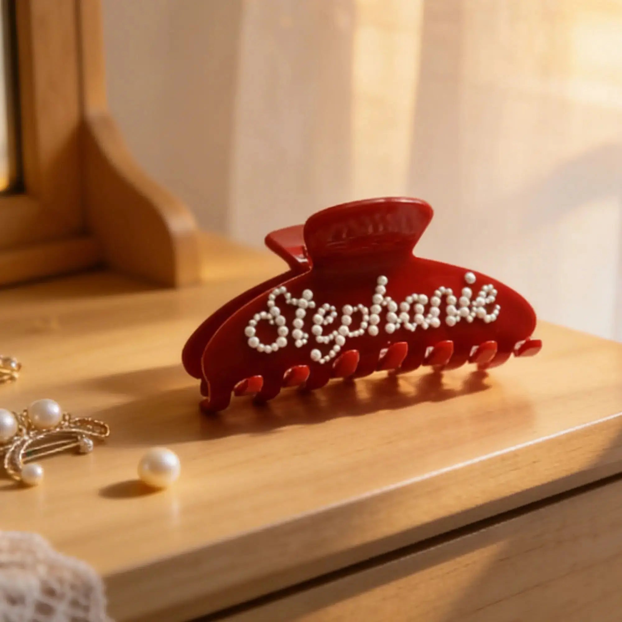 Red rhinestone hair claw clip with pearl-like beads across the teeth