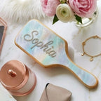 Wooden detangler brush with light blue cushion, gold border, clear rhinestone letters