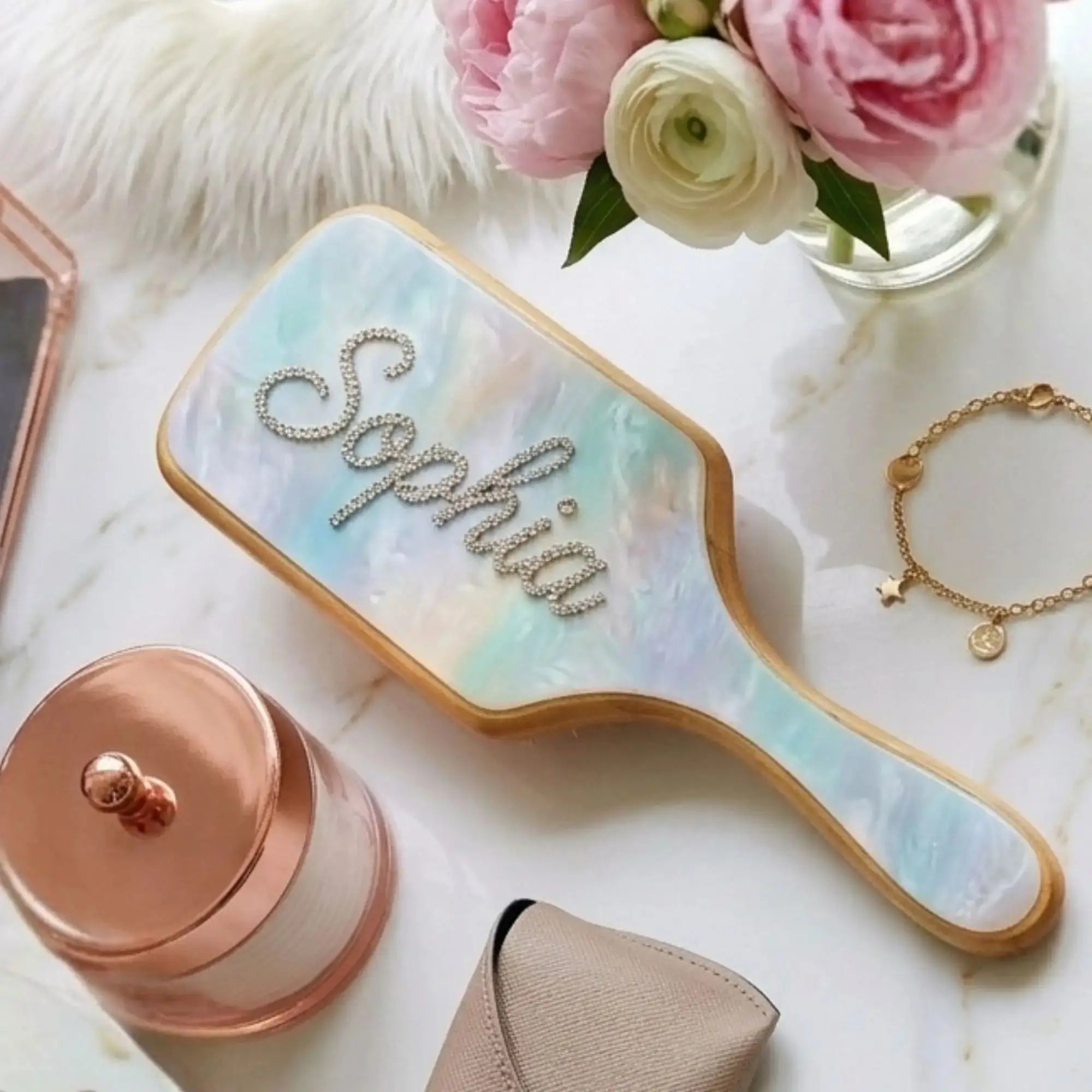 Wooden detangler brush with light blue cushion, gold border, clear rhinestone letters