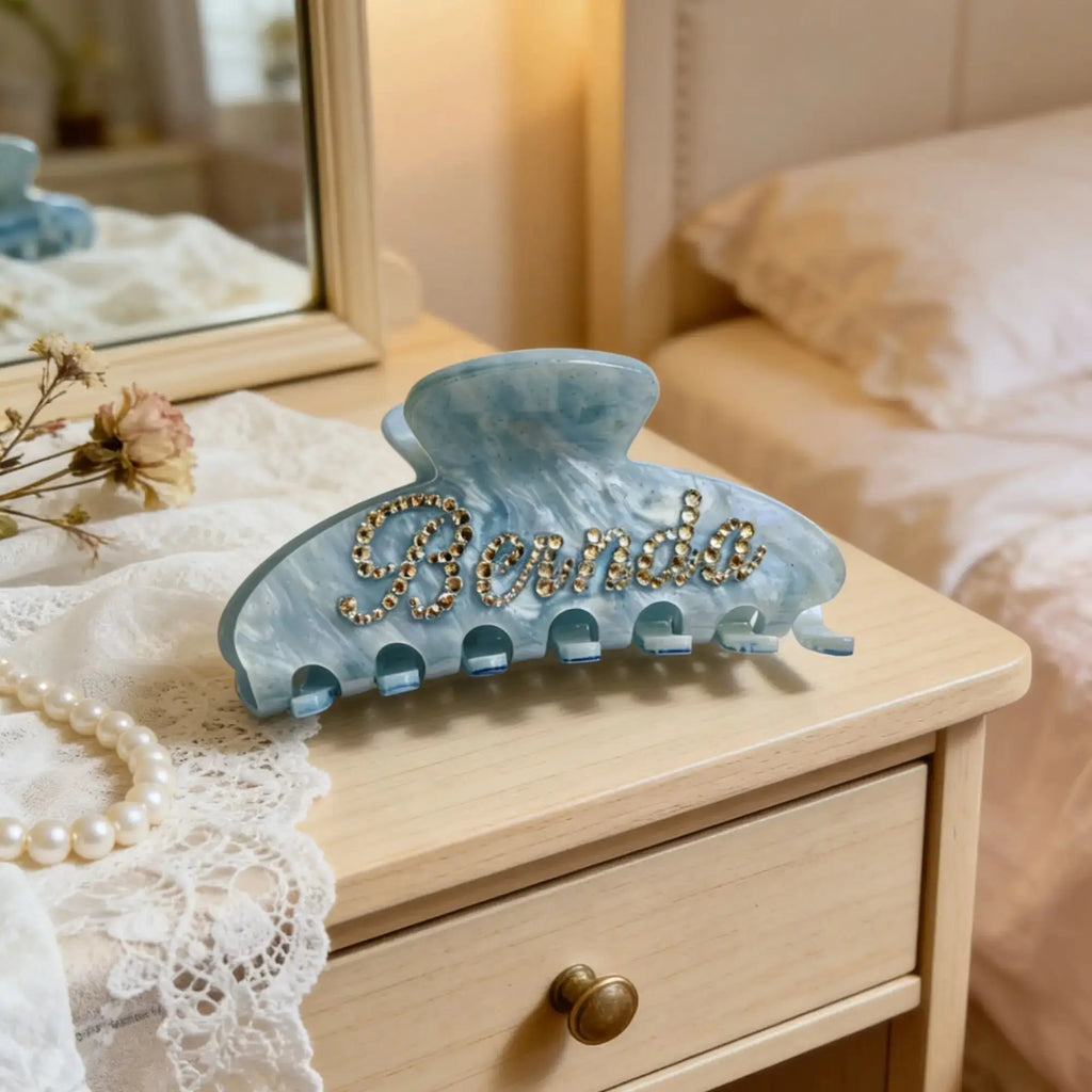 Blue hair claw clip with rhinestone text and pearl accents