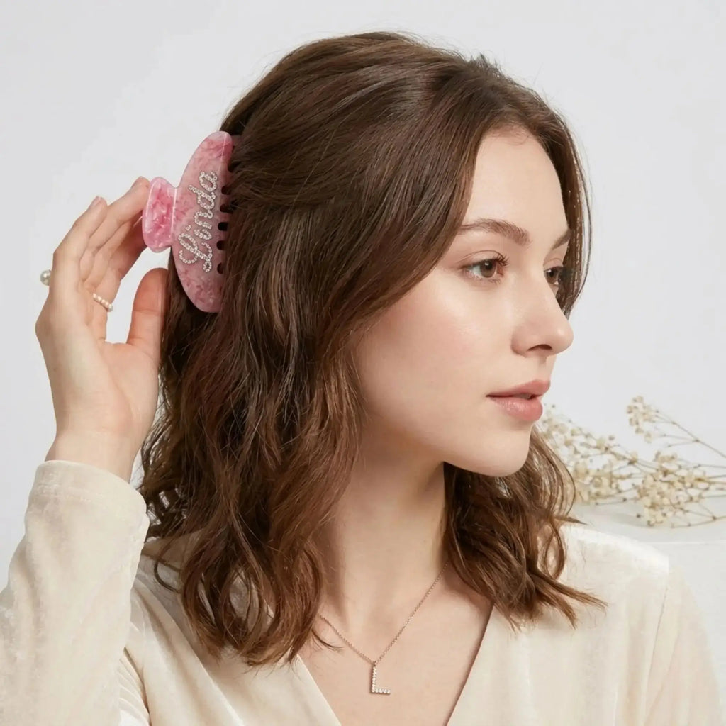 Pink rhinestone hair claw clip on dark brown hair, side view