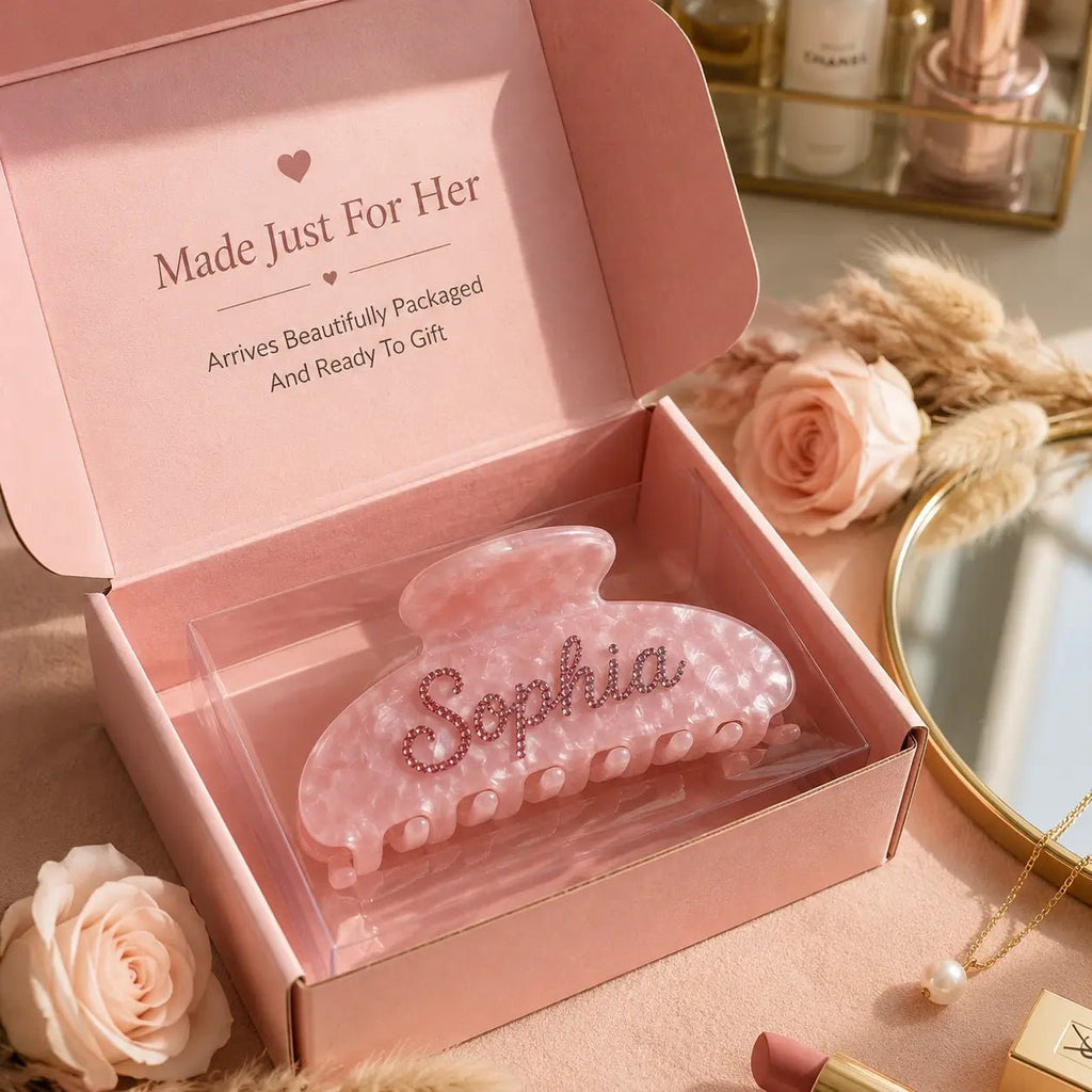 Pink translucent hair claw clip with engraved name and pearl-like studs.