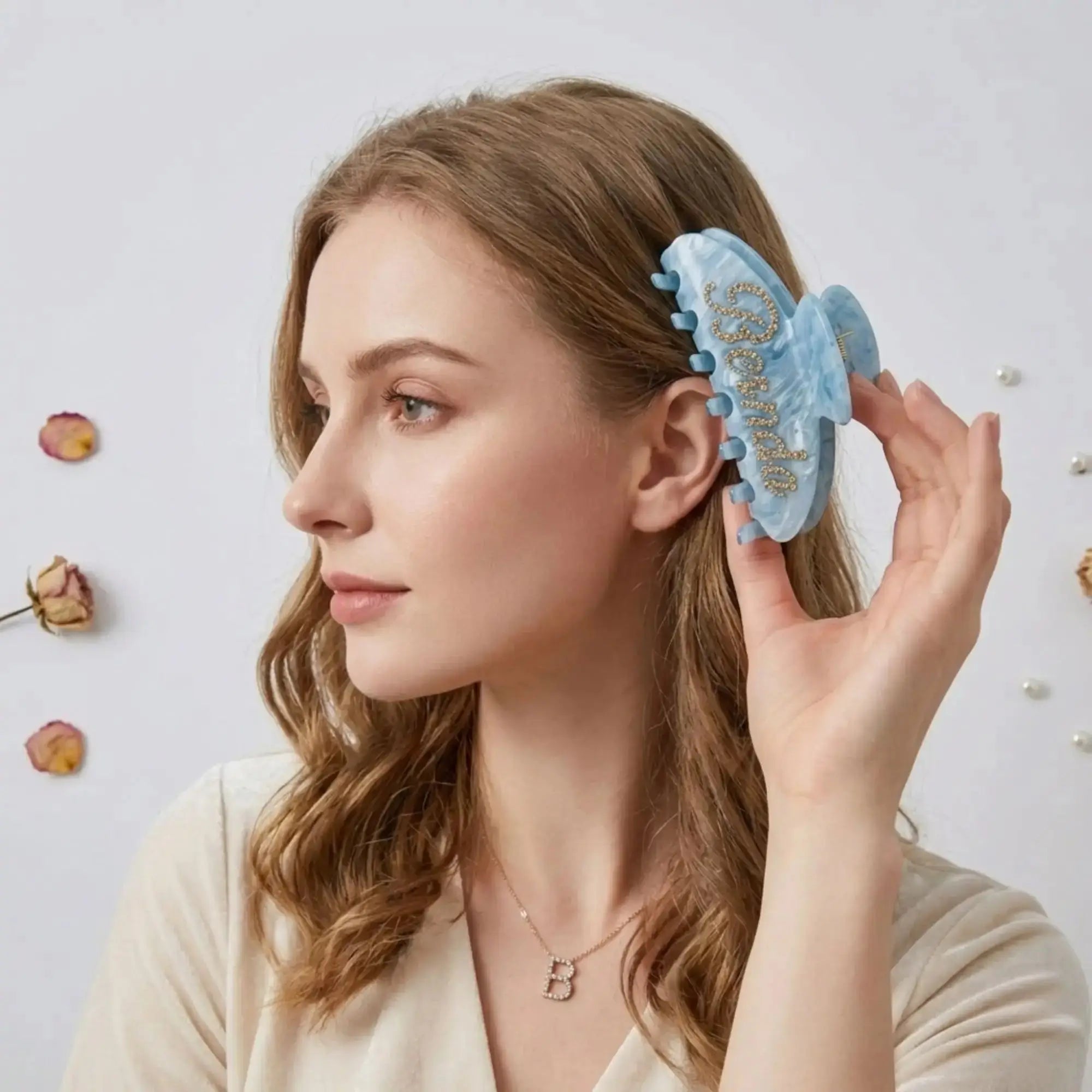 Light blue rhinestone hair claw worn on the side of the head