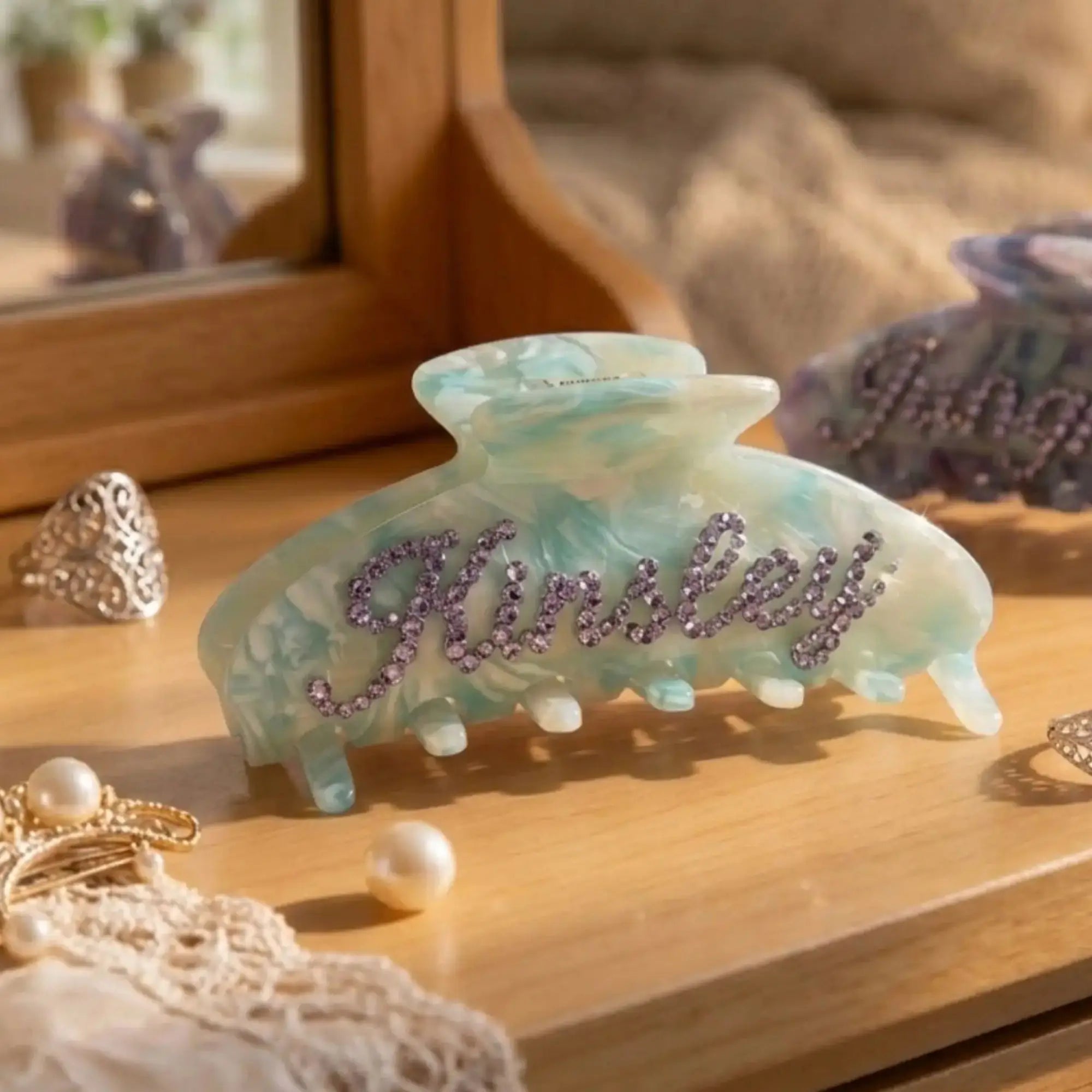 Blue opal hair claw clip with purple rhinestone monogram lettering.