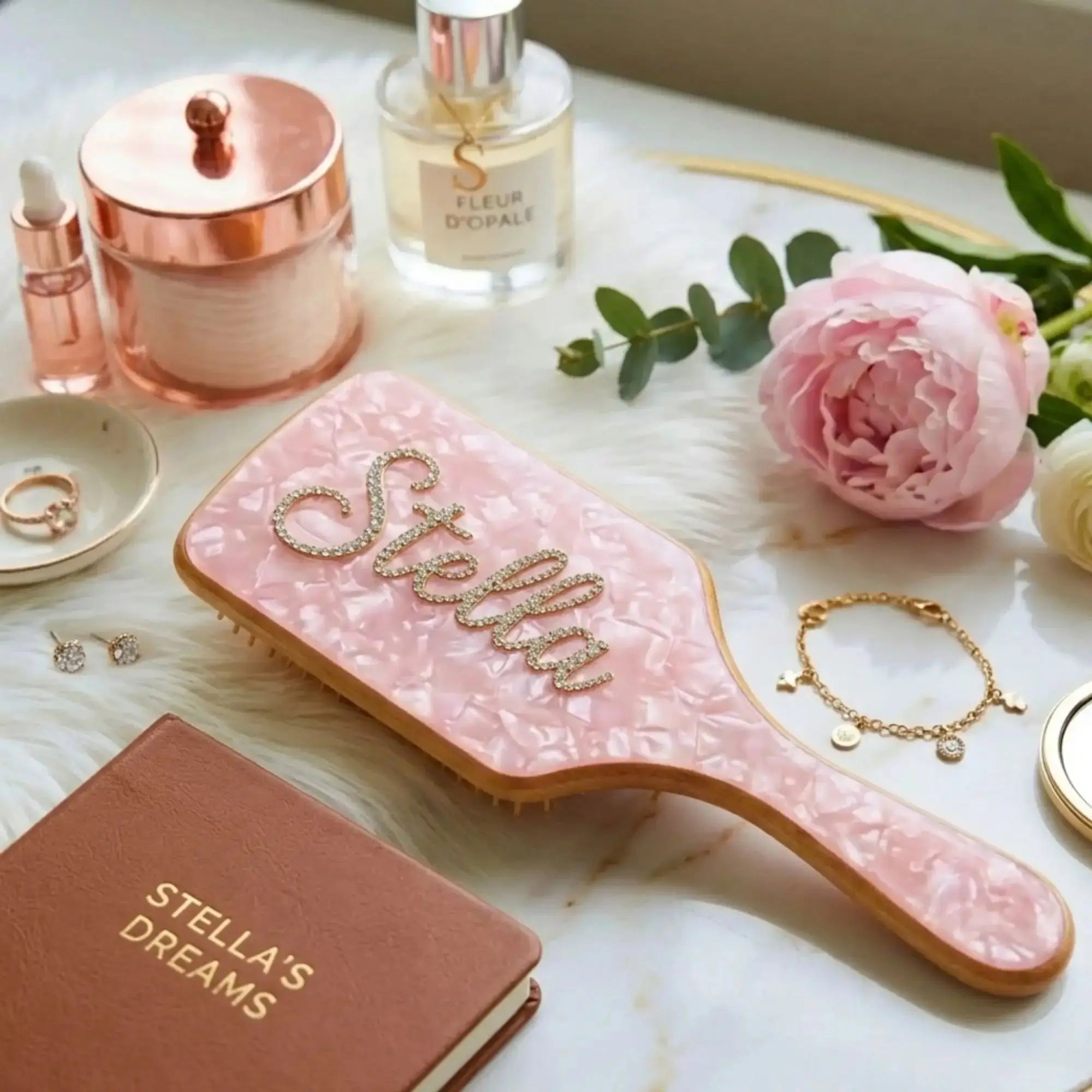 Air cushion hair brush with pink marbled cushion, wooden backing, and rhinestone script on top